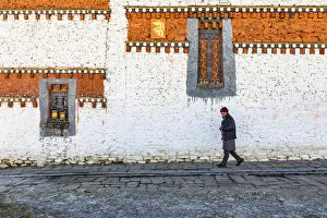 Prayer Gallery: A man walking around Jambey Lhakhang, Jakar, Bumthang District, Bhutan