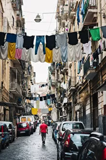Images Dated 3rd November 2021: Man walks in an alley in Naples, with clothes hanging between the buildings