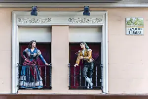 Paseo Del Prado Prints: Man and woman sculptures with traditional Spanish dressed on the balconies, Paseo