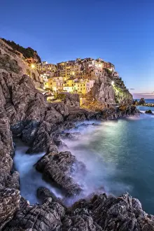 Cinque Terre Prints: Manarola village illuminated by the blue light of dusk with its typical pastel colored houses