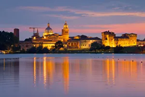 Mantova cityscape reflected in Mincio river at dusk. Mantova city, Mantova province