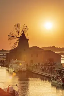 Saltern Prints: Marsala, Sicily. Tourists visiting the Marsala saltern at sunset with the windmill