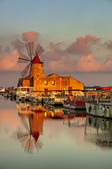 Marsala, Sicily. Windmills reflecting at sunrise in the saltern between Marsala