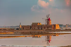 Marsala, Sicily. Windmills reflecting at sunrise in the saltern between Marsala