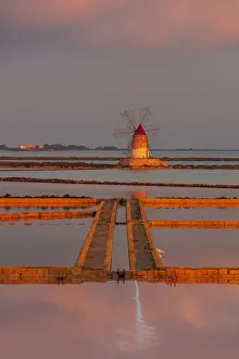Marsala, Sicily. Windmills reflecting at sunrise in the saltern between Marsala