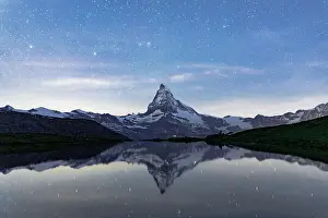 International Landmark Prints: Matterhorn mountain peak reflected in Stellisee lake under a romantic starry night sky