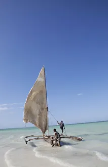 Two men sailing a boat in the surf off Zanzibar in East Africa Two men sailing a boat in the surf off Zanzibar in East Africa