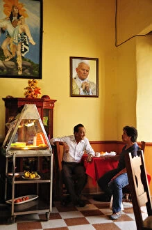 Images Dated 29th June 2012: Two men talking in a cafe in Santa Fe de Antioquia, Colombia, South America