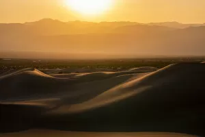 Mesquite Flat Sand Dunes and silhouette rocky mountains in desert during sunset