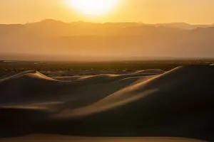 Desolate Prints: Mesquite Flat Sand Dunes and silhouette rocky mountains in desert during sunset
