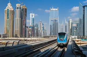 Metro train with city skyline in the background, Dubai, United Arab Emirates