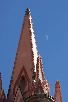 Mexico. A church steeple against a blue sky with the faint outline of the moon
