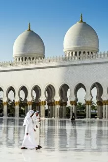 Arabian Peninsula Collection: Two Middle Eastern men traditionally dressed walking in the courtyard of the Sheikh Zayed Mosque
