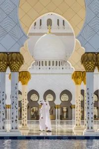 Abu Dhabi Prints: Two Middle Eastern men traditionally dressed walking in the courtyard of the Sheikh Zayed Mosque