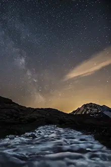 Milky Way Prints: The Milky Way shining over Mount Disgrazia while a stream is quietly flowing towards