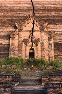 Mingun, Sagaing region, Myanmar (Burma). Woman with red umbrella climbs the stairs