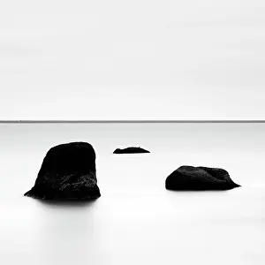 B And W Prints: Minimalist image of 3 rocks in a frozen lagoon in winter, near Vik y Myrdal, South Iceland