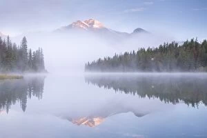 Images Dated 3rd September 2015: A mist shrouded Pyramid Mountain reflected in Pyramid Lake at dawn, Jasper National Park
