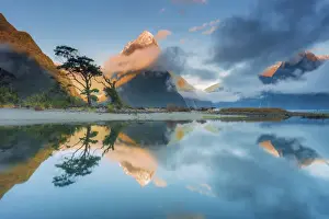 Mitre Peak reflecting in the fjord water at sunset at Milford Sound in New Zealand