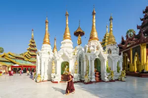 Gold Gallery: Monk walking by White temple in Shwedagon Pagoda complex, Yangon, Yangon Region, Myanmar