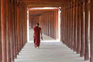 Inside Prints: Monk in walkway of wooden pillars to temple, Salay, Myanmar, (Burma)