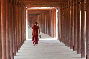 Burma Gallery: Monk in walkway of wooden pillars to temple, Salay, Myanmar, (Burma)