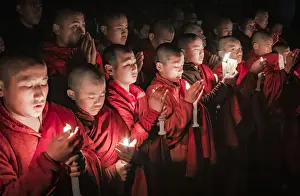 Monks during evening candle light prayer in Lhodrak Kharchu monastery, Jakar