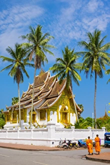 Images Dated 10th May 2015: Monks passing Haw Pha Bang temple on the grounds of the Royal Palace, Luang Prabang
