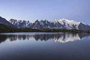 The Mont Blanc mountain range reflected in the waters of Lac de Chesery at sunrise