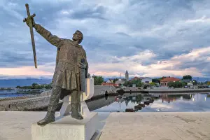 Dalmatian Prints: monument of Branimir of Croatia in Nin, on the background the old bridge that connects