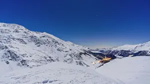 Ski Resort Prints: Moonlight over snowcapped mountains surrounding Madesimo on a cold winter night