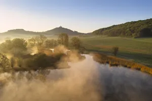 Morning mist over pond with Wachsenburg castle in the background