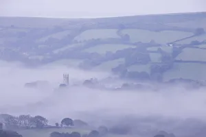 Church Tower Gallery: Morning mist swirls around the church tower of Widecombe in the Moor, Dartmoor, Devon