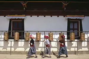 Mosu women push prayer wheels at a small monastery on Liwubi Island