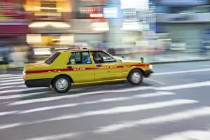 Taxi Prints: Motion blurred yellow taxi cab on pedestrian crossing, Tokyo, Japan