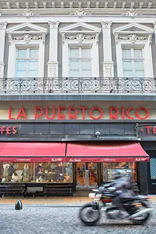 Buenos Aires Prints: A motorbike passing by the exterior facade of 'La Puerto Rico' Notable Cafe