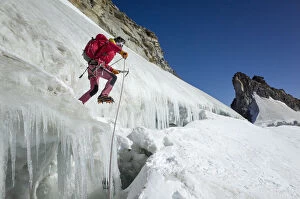 Icicles Collection: Mountaineer on ice jumps the final crevasse before reaching the Gran Paradiso peak