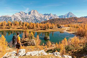 October Prints: A mountaineer staring at Federa Lake with the Dolomite mountains in the background