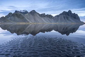 The mountains reflect on the surface of the ocean. Stokksnes, Eastern Iceland, Europe