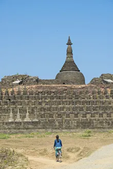 Mrauk-U, Rakhine state, Myanmar. Woman cycling near Koe-Thaung pagoda