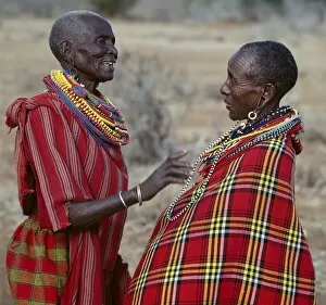 Maasai Tribe Collection: Two Msai women in traditional attire chat to each other
