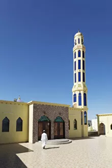 Islamic Architecture Collection: A mullah walks into a colourful mosque for the call to prayer, Nizwa, Ad Dakhiliyah