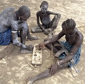 Adornment Collection: Two Mursi men with singular hairstyles play a game
