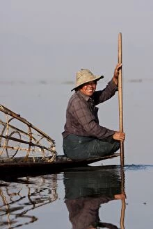 Paddle Gallery: Myanmar, Inle Lake. Intha fisherman gently paddling his boat across Inle Lake, Myanmar