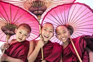 Oriental Flavours Gallery: Myanmar, Mandalay division, Bagan. Portrait of three novice monks under red umbrellas