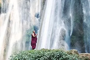 Images Dated 22nd January 2014: Myanmar, Mandalay division, Pyin Oo Lwin. Burmese monk praying under Dattawgyaik Waterfall