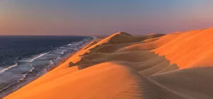 Images Dated 24th February 2023: Namibia, Walvis Bay, Namib desert sand dunes reaching the ocean