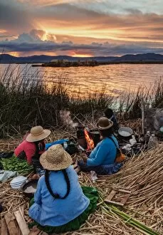 Andes Collection: Native Uro Family dining at sunset, Uros Floating Islands, Lake Titicaca, Puno Region