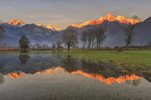 Natural reserve of Pian di Spagna flooded with snowy peaks reflected in the water