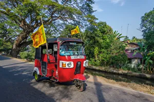 Sri Lanka Prints: Negombo, Western Province, Sri Lanka, Southern Asia. A Red Tuk Tuk running in the streets